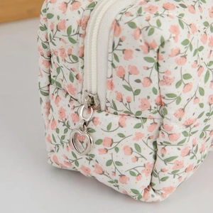 Floral quilted cosmetic bag with pink flowers and silver heart-shaped zipper puller