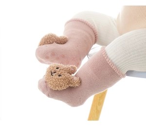 Dettaglio calzini rosa neonato con orsetto 3D e gommini antiscivolo sulla suola