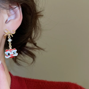 Detail of lion dance earrings with golden bows and crystals worn on a model's ear