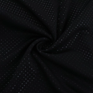 Détail macro du tissu noir brillant à pois pour combinaison sexy dos nu chic