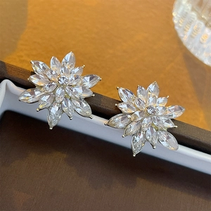 Macro detail of elegant marquise-cut crystal flower earrings on a luxury jewelry box