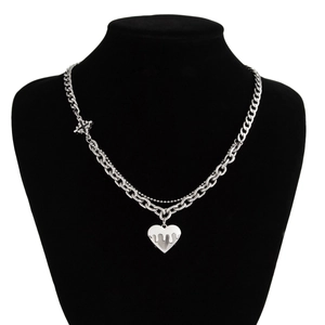 Close-up of double-layer silver Cuban chain and bead necklace with molten heart pendant