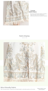 Détail d'une robe longue à imprimé cachemire avec ourlet à franges et boutons décoratifs