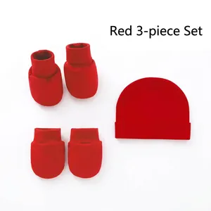 Detailed view of red newborn 3-piece set with cotton hat, socks and anti-scratch mittens
