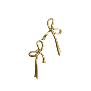 Elegant gold bow earrings with a polished metal finish on a minimalist white background