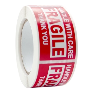 Red fragile adhesive labels roll with bold white handle with care text for shipping