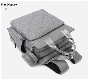 Detail view of grey quilted diaper backpack with large diamond texture and round side pouch