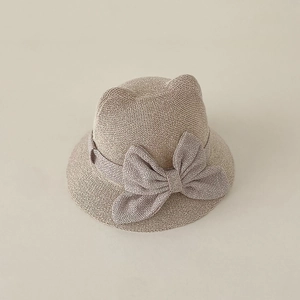 Detailed knit texture of baby straw hat with cat ears and large decorative bow