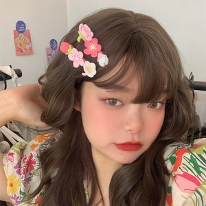 Close-up of cute pink and white flower hair clips worn on the side by a model