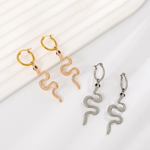 Macro detail of gold and silver cobra snake earrings with textured scales and black eyes