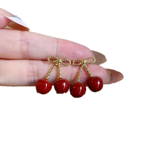 Red cherry pendant earrings with golden bow detail on silver needles for women