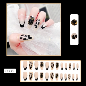 Detail view of long French nails with black tips, leopard print, and gold foil texture