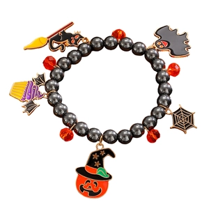 Detalle de pulsera de cuentas de Halloween con dijes de calabaza, murciélago y araña