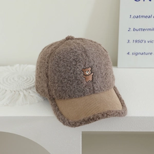Close-up of fluffy brown lamb wool baseball cap with cute bear embroidery detail
