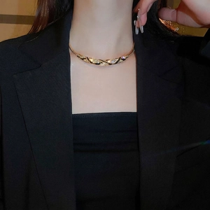 Vintage gold necklace with black enamel and sparkling diamonds worn on a neck