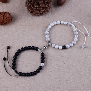 Close-up of magnetic heart couples bracelets with black matte and white marble beads