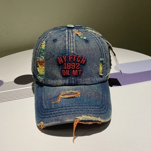 Macro shot of embroidered NY FTCH lettering on blue washed denim baseball cap texture