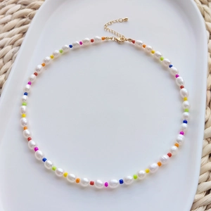 Detailed close-up of handmade rainbow beaded choker with natural freshwater pearls and gold clasp