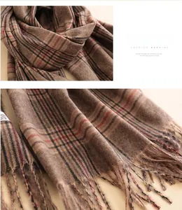 Detail of brown plaid cashmere scarf showing thick texture and long fringe edges