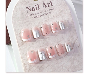 Detailansicht von rosa French-Nagelspitzen zum Aufkleben mit Schleifen und Punktmuster