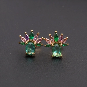 Macro shot of gold-plated cluster earrings with green, pink, and purple zircons