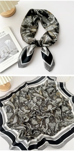 Detail of elegant paisley silk scarf with olive green and gold patterns on a table