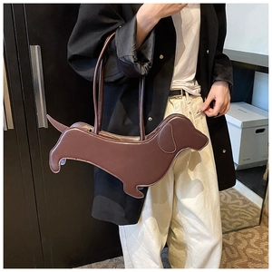 Detail of creative brown dachshund dog-shaped leather handbag shown on shoulder