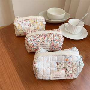 Detailed close-up of three quilted floral cosmetic bags with vintage cotton patterns