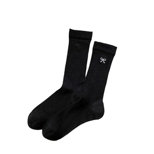 Japanese style black ribbed slouch socks with delicate white bow embroidery on pure background