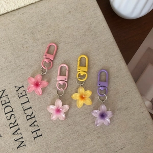 Set of four colorful translucent resin flower keychains on a vintage book cover