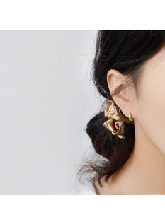 Close-up of elegant gold geometric hoop earrings on a model wearing a silk hair tie