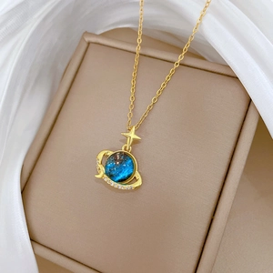 Elegant gold celestial star and moon necklace with sparkling blue planet pendant on silk
