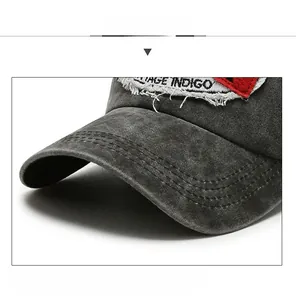 Macro detail of dark grey washed denim visor with reinforced stitching and raw edge
