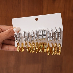 Close-up of 12-piece earring set featuring gold and silver geometric wave and hoop styles