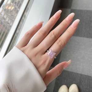 Gros plan d'une bague en zircon rose coupe fleur de glace sur une main de femme