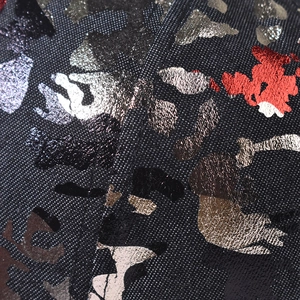 Macro detail of Chinese style baseball cap fabric with gold and silver metallic camo foil