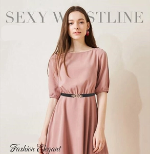 Detail of elegant gold leaf buckle and black elastic waist belt on pink dress