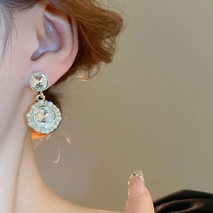 Close-up of vintage French earrings with pearls and crystals worn by a model