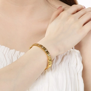 Detail of 18K gold-plated oval bangle with white zircons on a model's wrist