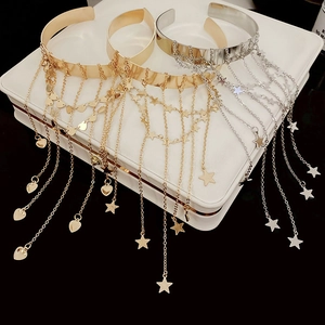 Detail of gold and silver arm cuffs featuring star and heart fringe tassel pendants