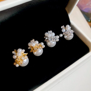 Detailed cluster of pearl and zircon earrings in gold and silver plating on velvet