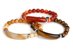 Detail of beaded bracelets with red agate, tiger eye and silver spacers on white background