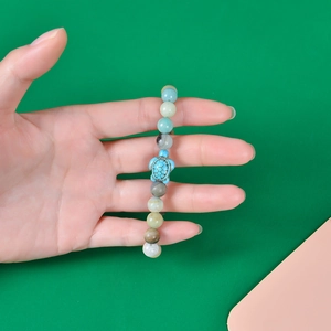 Detailed shot of handmade beaded bracelet featuring a light blue sea turtle charm