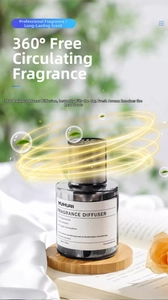 Close-up of a 160ml dark glass fragrance diffuser on a round wooden base with silk