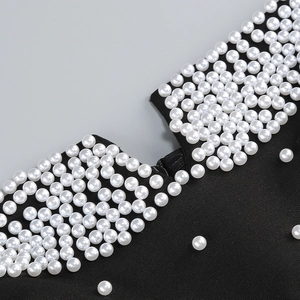 Détails des perles décoratives et de la fermeture éclair sur robe noire élégante