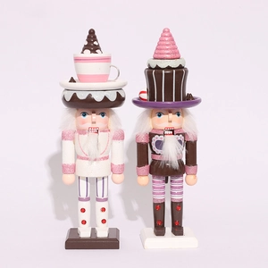 Detail of pink and brown nutcracker figures with tea cup and cupcake toppers
