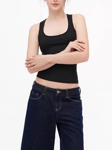Slim fit black racerback tank top paired with high-waisted dark blue jeans for sports