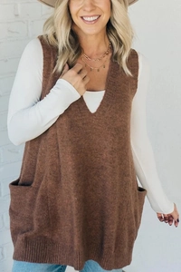 Detail shot of a V-neck knit vest in brown with side pockets and smooth knitting texture