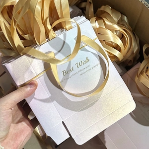 Détail du sac cadeau dégradé rose avec anses en satin doré et texte Best Wish