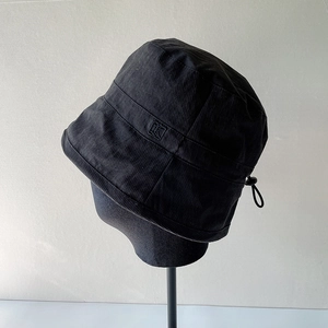 Detail of lightweight black bucket hat featuring corduroy texture and adjustable drawstring